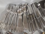 a lot of silverware on a table with spoons and spoons