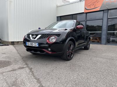 La Nissan Juke noire est garée devant un immeuble.