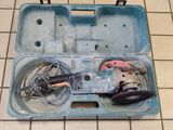 une boîte à outils bleue contenant des outils, posée sur un sol carrelé