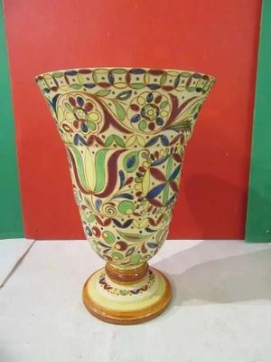 a vase on a table with a red wall in the background