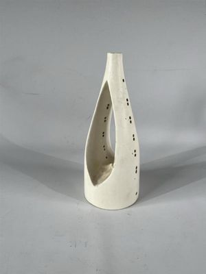 un vase blanc percé d'un trou, sur fond blanc