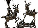 two bronze statues of deer and a man on a sleigh