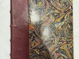 un vieux livre avec une couverture marron ornée d'un motif en spirale
