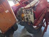 a red tractor with a sign on the front of it