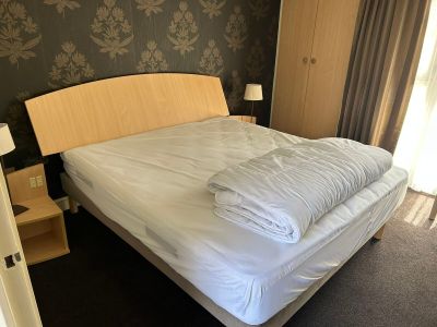 un lit recouvert d'une couette blanche dans une chambre d'hôtel