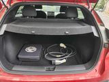 the trunk of a red car with a laptop in the trunk