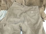 a pair of pants and a jacket laying on a bed