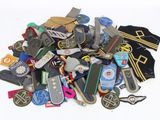 a pile of assorted skateboards and badges on a white surface