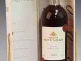 an old bottle of wine sitting inside of a box on top of a table