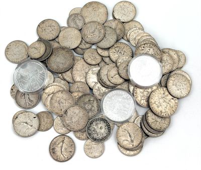une pile de vieilles pièces d'argent sur une surface blanche