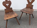 pair of antique wooden chairs with hearts on the back of them
