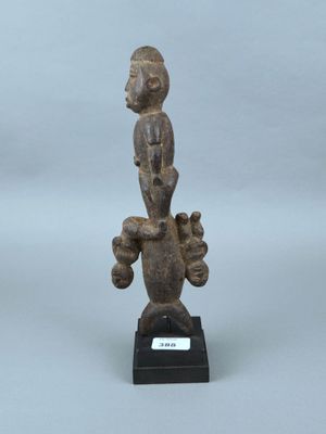 une petite statue représentant un homme avec un oiseau sur la tête