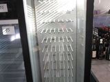 une vitrine en verre contenant de nombreuses bouteilles de vin