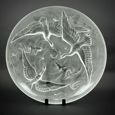 une plaque de verre ornée d'un motif représentant un oiseau et un poisson