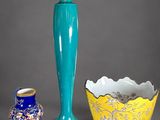 three vases and a candle holder on a table