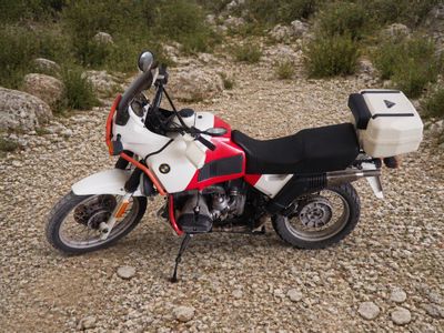 une moto blanche et rouge garée sur le bord de la route