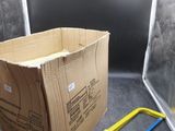 une boîte en carton avec une poignée jaune à côté d'une scie