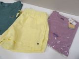 three pairs of shorts and a t - shirt sitting on a table