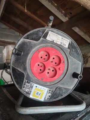 a red and black electrical outlet on top of a black table