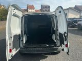 une camionnette blanche dont les portes sont ouvertes, garée sur un parking
