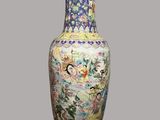 a vase with a painting on it sitting on a table