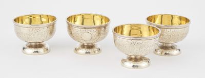 three silver goblets are sitting next to each other on a white surface