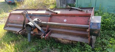 une grosse machine rouge qui est garée dans l'herbe