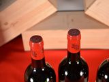 three bottles of wine sitting on a red table