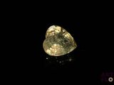 a close up of a yellow diamond on a black surface