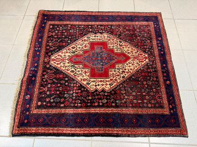 un tapis posé au sol, orné d'un motif rouge et bleu