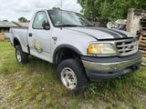 a truck that is parked on the grass in the yard