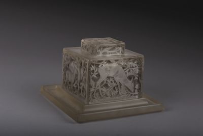 une boîte en verre décorée d'un motif, posée sur un socle