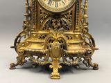 a gold clock sitting on top of a table