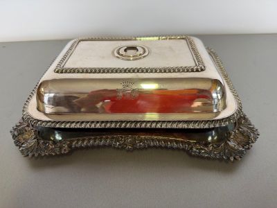 a silver plate with a glass lid on a table