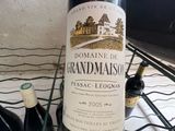 a bottle of wine sitting on a table next to two bottles of wine
