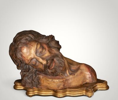 an image of a statue of a man laying on top of a wooden base