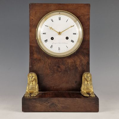 une image représentant une horloge en bois flanquée de deux lions de chaque côté