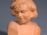 sculpture of a child ' s head on a wooden stand