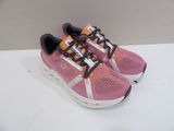 pink and orange running shoes with black laces on a white surface