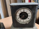 a small clock sitting on a table in a room