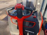 a red and black fork lift truck parked on the side of the road