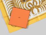 yellow and white scarf with orange square box on grey background