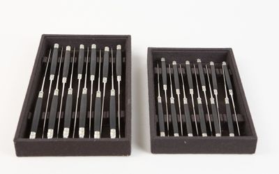 two black boxes filled with different types of needles on a white surface