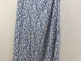 a blue and white floral skirt hanging on a hanger
