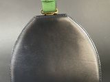 black and green handbag with a green strap on a gray background