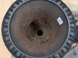 a large black vase sitting on a rug on the floor