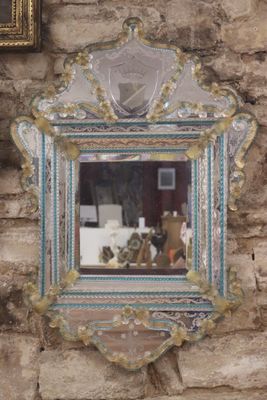 a mirror hanging on a brick wall with a picture on it