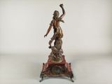 bronze statue of a woman holding a bird on top of a table