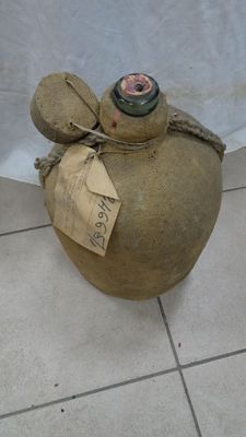 a bottle that is sitting on the floor with a tag on it