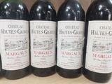six bottles of red wine are lined up on a shelf